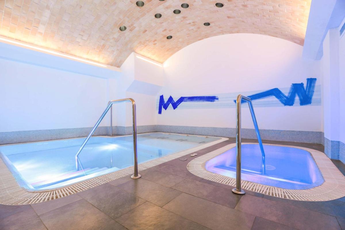 una piscina en una habitación con jacuzzi en MYR Plaza Mercado & Spa, en Valencia