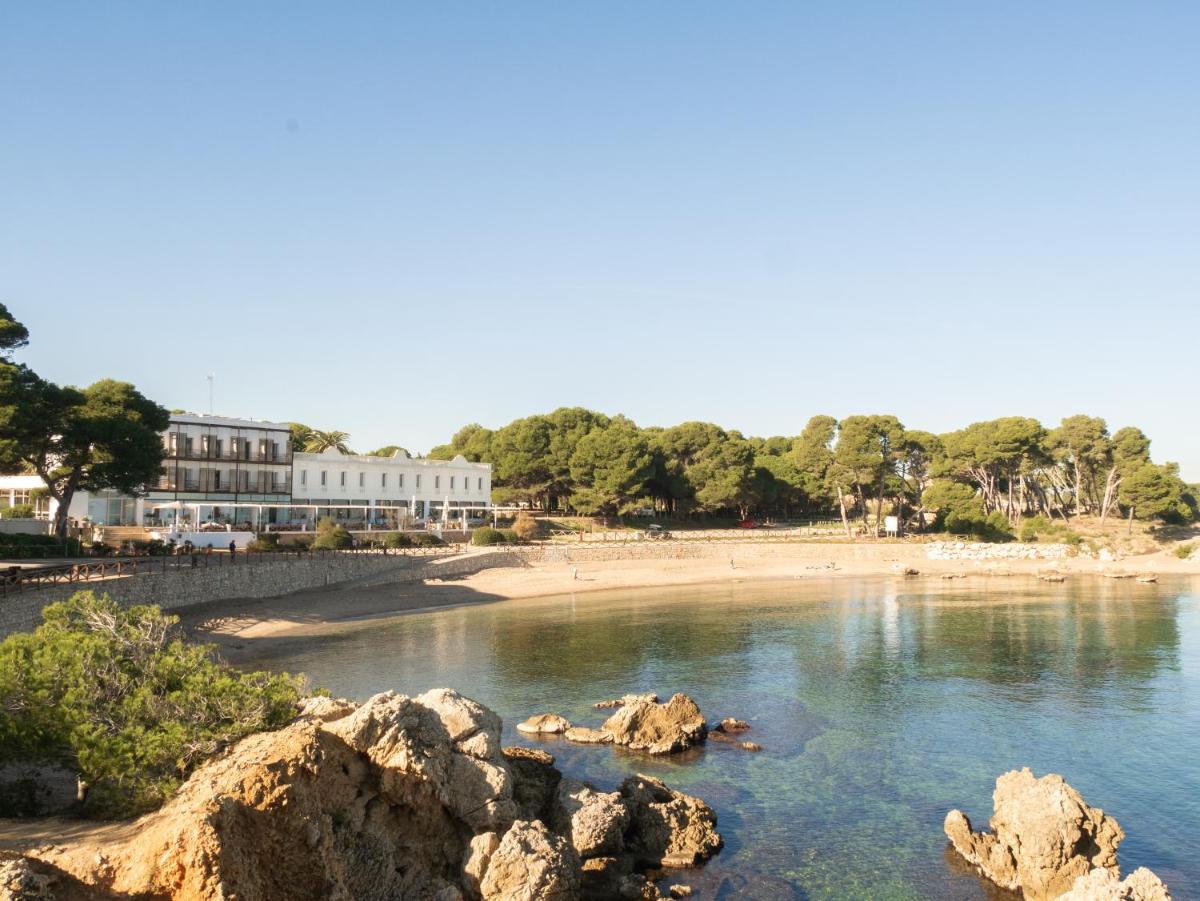 Una vista de una playa con rocas en el agua. en Hostal Empúries, en L'Escala