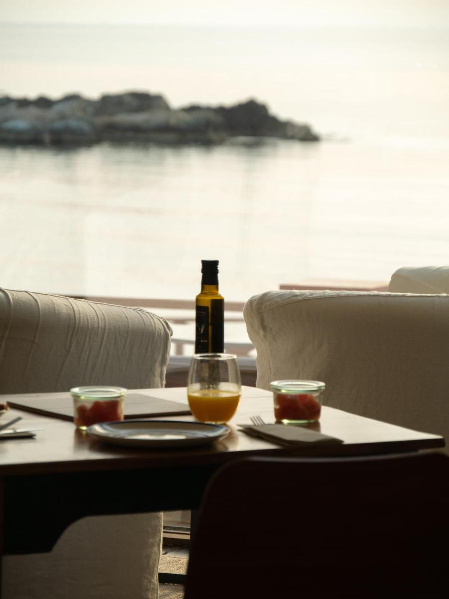 Una botella de vino sobre una mesa con una copa. en Hostal Empúries, en L'Escala