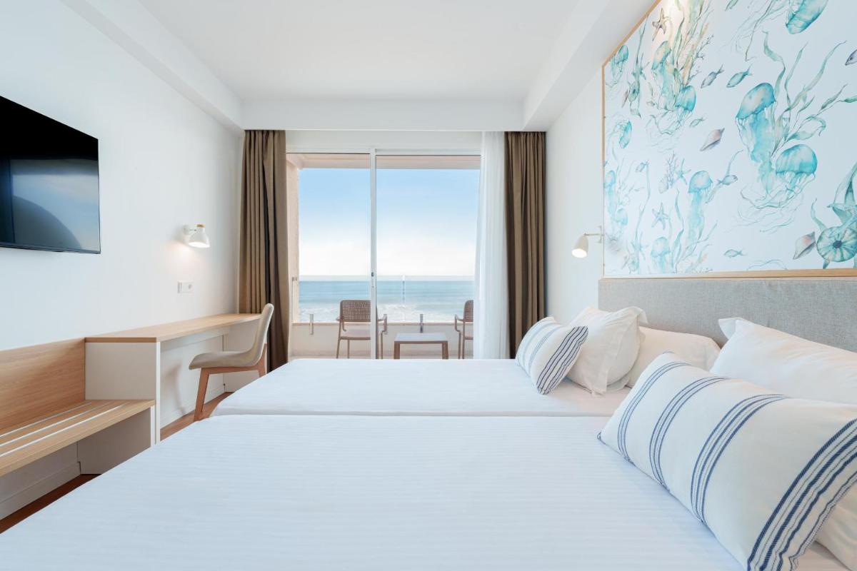 Una habitación de hotel con dos camas y vista al mar. en Ferrer Concord Hotel & Spa, en Can Picafort