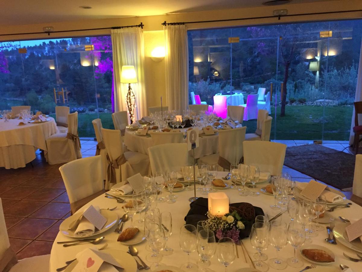 Un comedor con mesas blancas y sillas blancas. en Hotel Golf Can Rafel, en Corbera de Llobregat