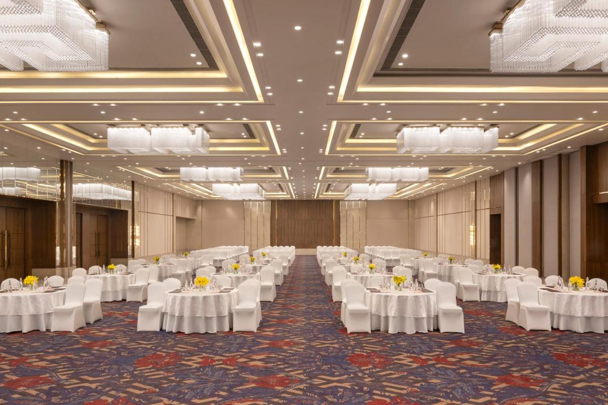 a banquet hall with white tables and white chairs at Welcomhotel by ITC Hotels, Delhi-Gurugram Highway in New Delhi