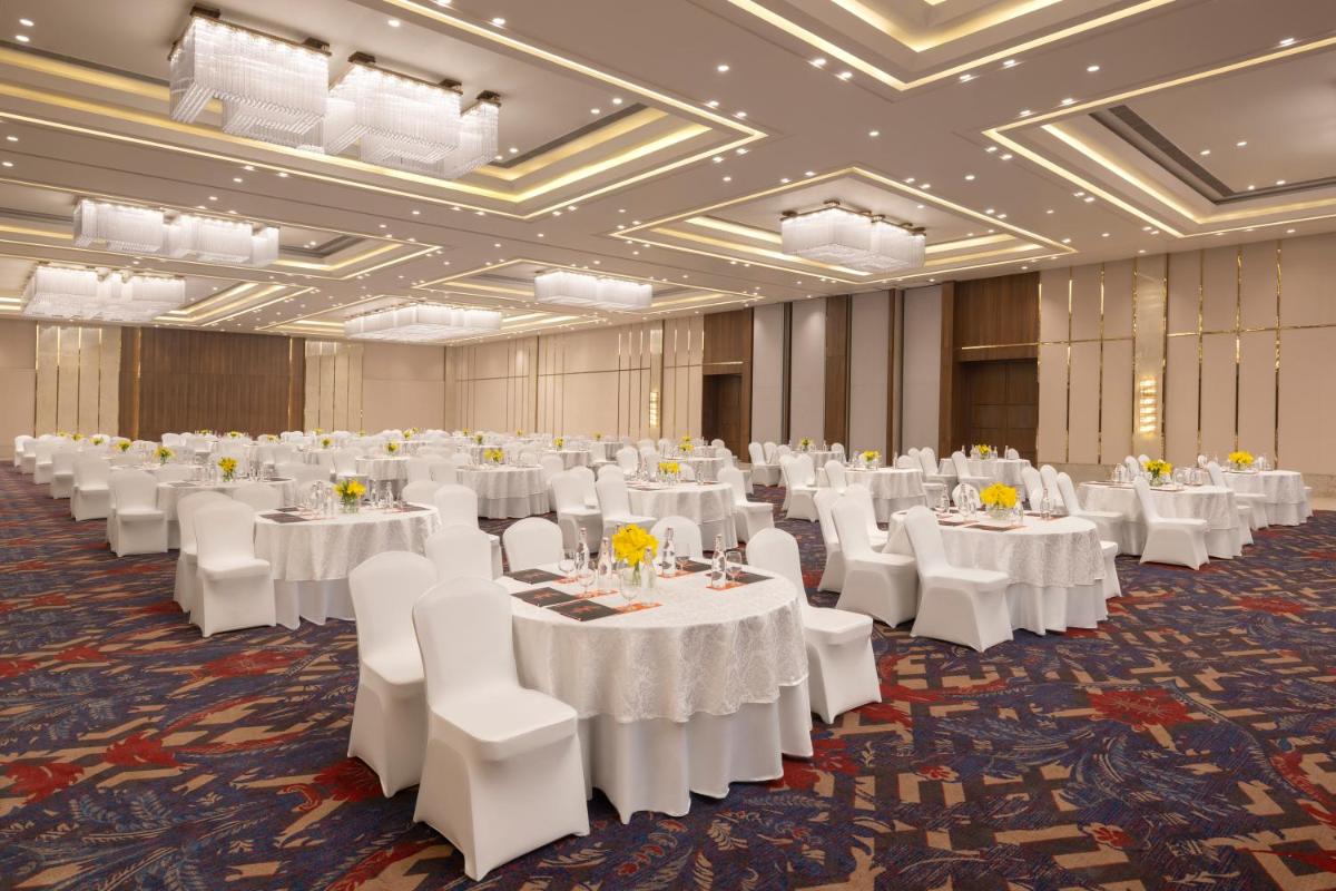 a banquet hall with white tables and white chairs at Welcomhotel by ITC Hotels, Delhi-Gurugram Highway in New Delhi