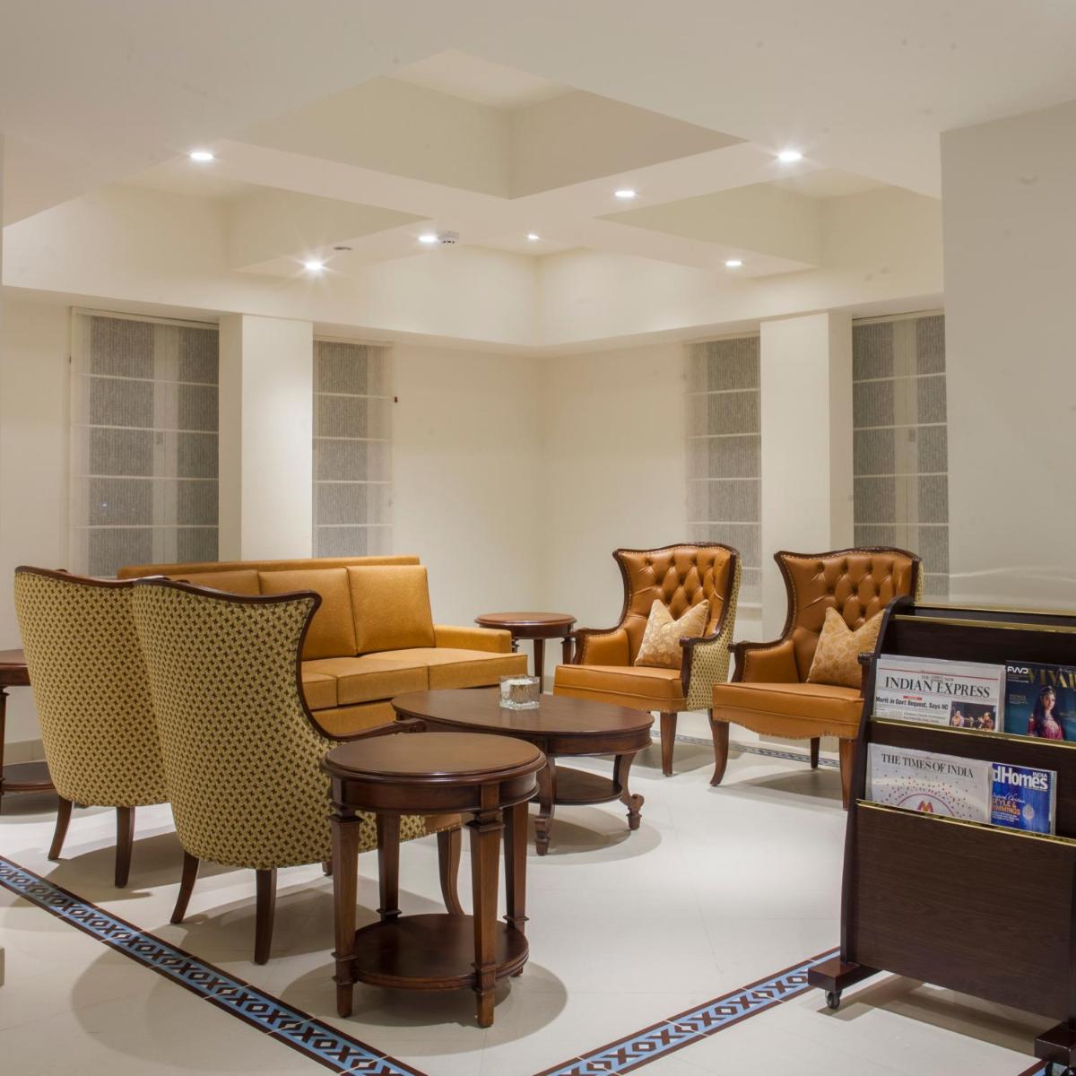 a waiting room with couches and tables and chairs at Fragrant Nature Kochi - A Five star Classified Hotel in Cochin