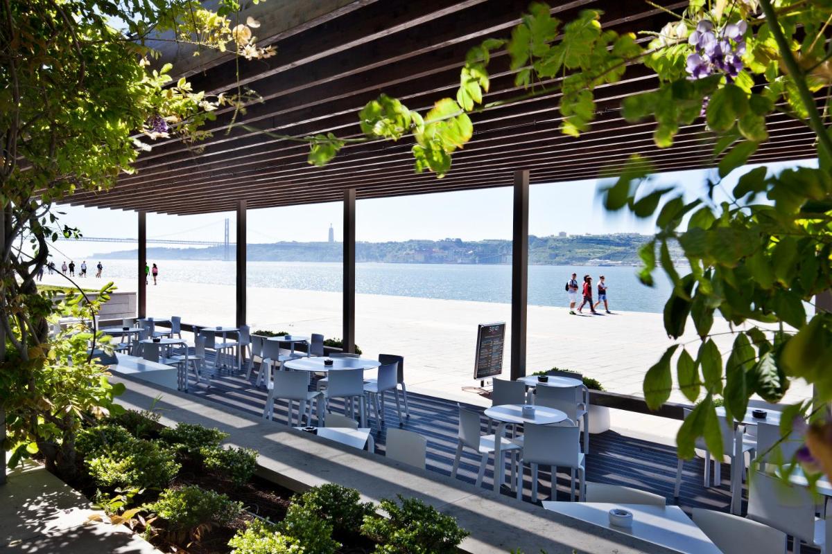 um grupo de mesas e cadeiras na praia em Altis Belem Hotel & Spa, a Member of Design Hotels em Lisboa