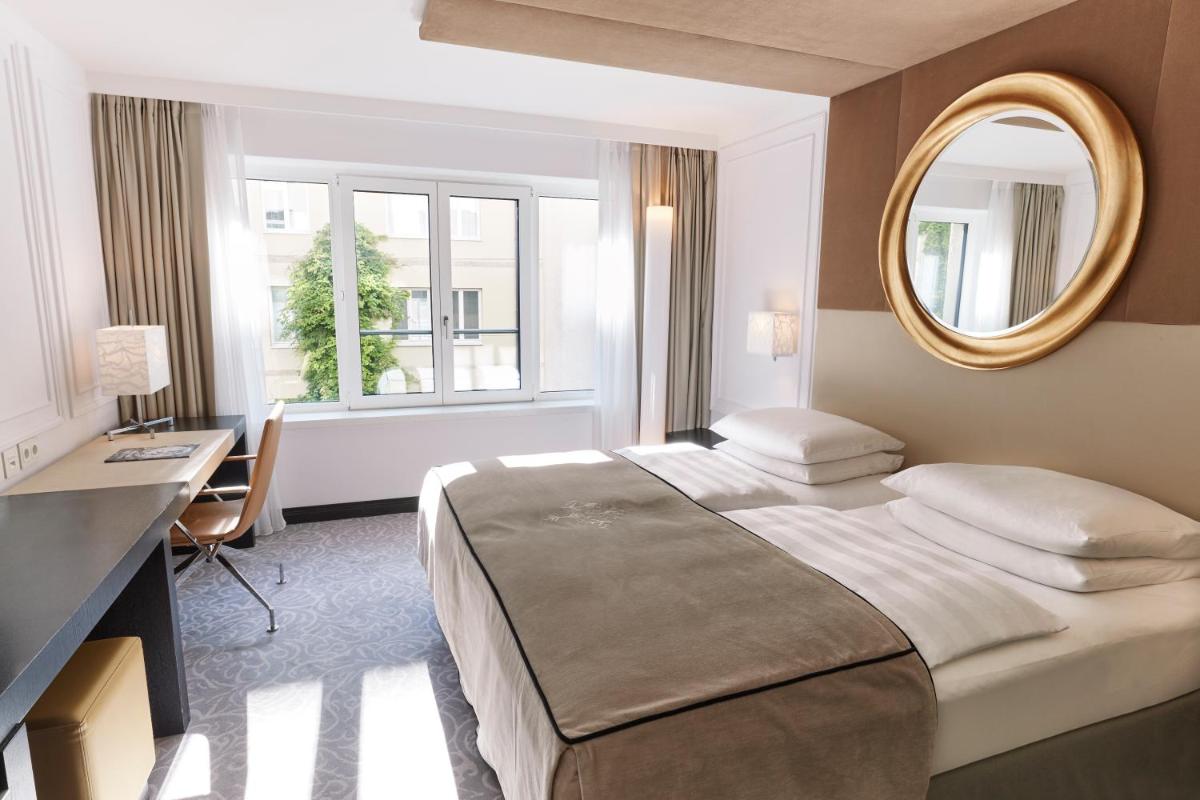 Ein Bett oder Betten in einem Zimmer der Unterkunft Vier Jahreszeiten Kempinski München