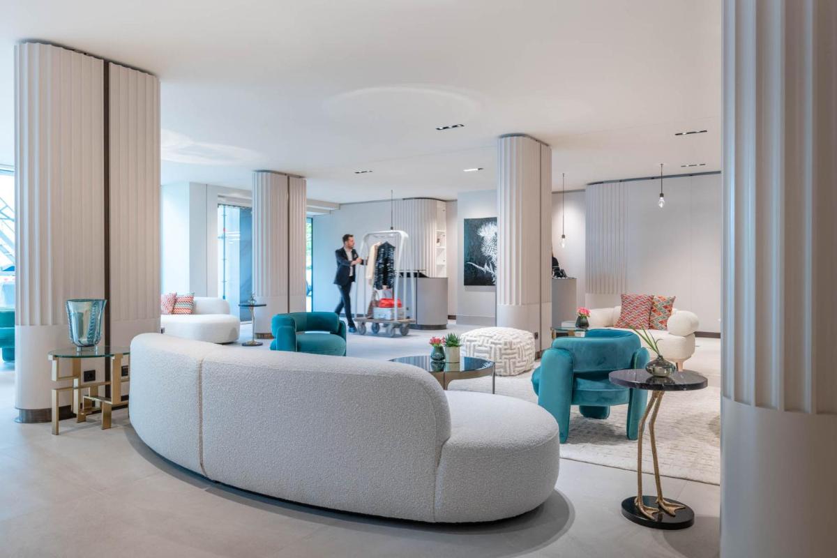 ein Wohnzimmer mit einem weißen Sofa und blauen Stühlen in der Unterkunft RIVA - Das Hotel am Bodensee in Konstanz + 37 Fotos