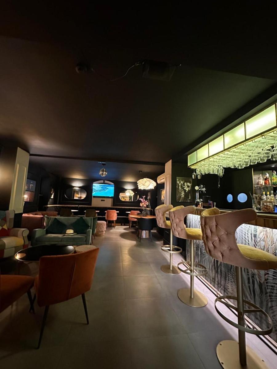 um restaurante com cadeiras e um bar num quarto em Storytellers Palace em São Martinho do Porto