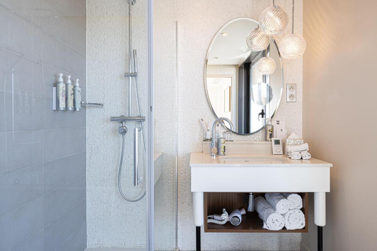une salle de bains avec lavabo et douche avec miroir dans l'établissement Renaissance Aix-en-Provence Hotel, à Aix-en-Provence