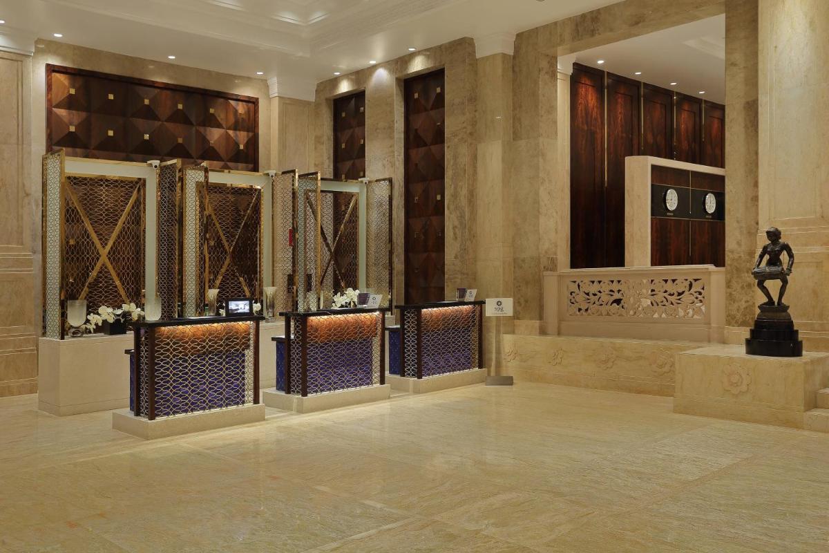 a lobby with a statue in the middle of a building at Sheraton Grand Pune Bund Garden Hotel in Pune