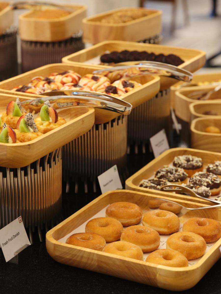 a display of different types of pastries in wooden trays at The Leela Hyderabad Banjara Hills in Hyderabad