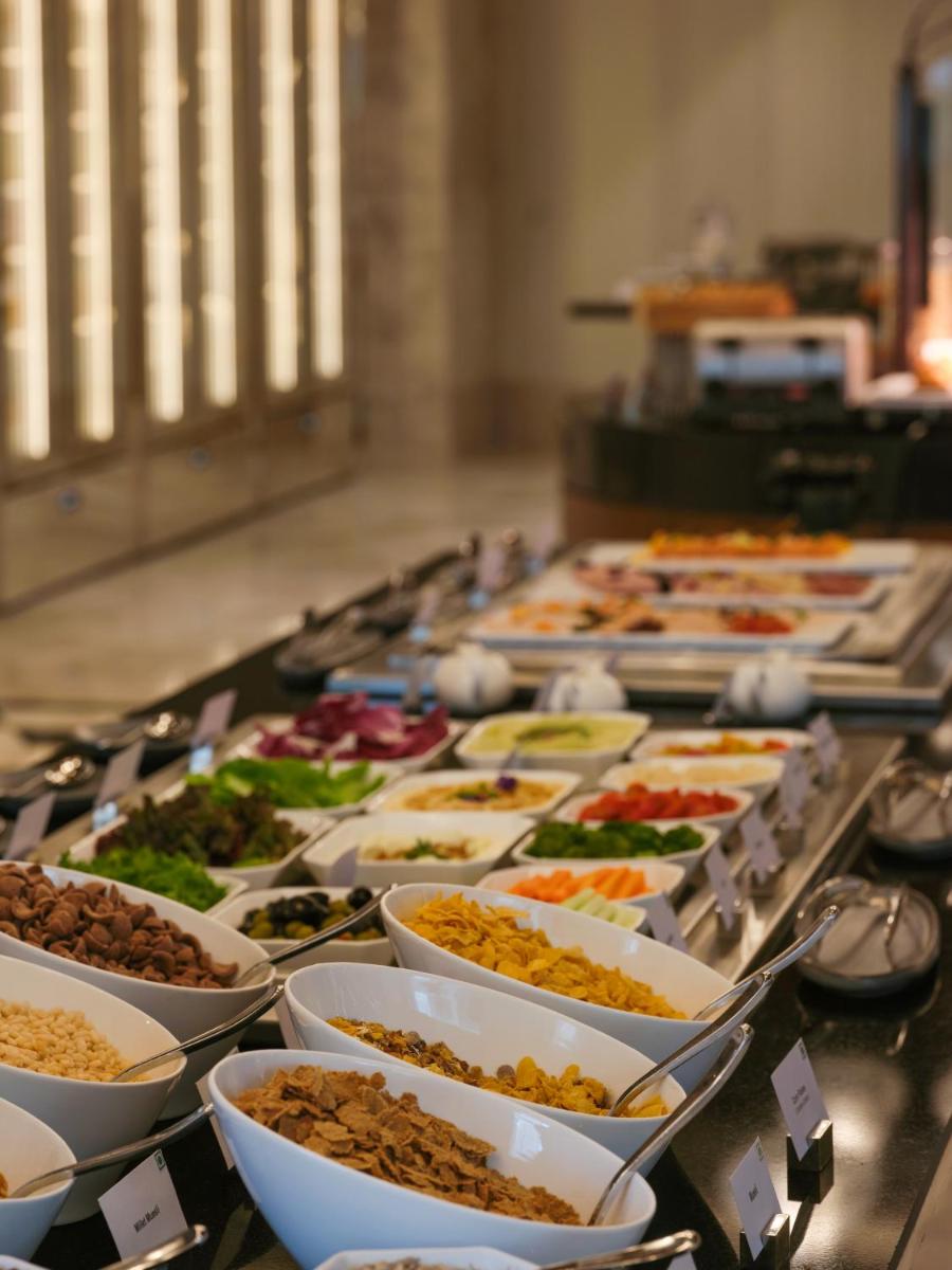 a buffet line with many bowls of different foods at The Leela Hyderabad Banjara Hills in Hyderabad