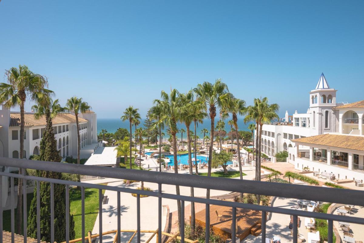 Una vista desde el balcón de un resort con palmeras. en DAIA Slow Beach Hotel Conil - Adults Only Recommended, en Conil de la Frontera