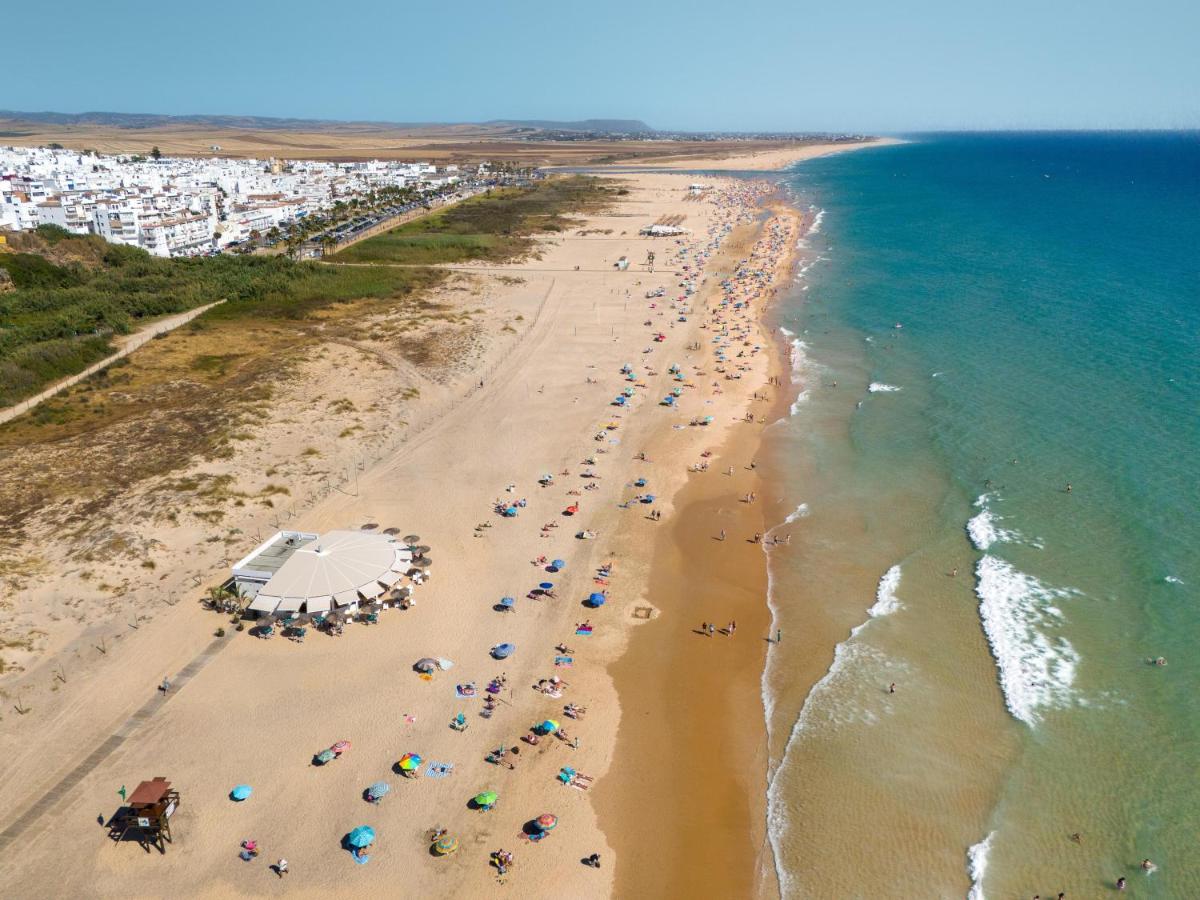 Una vista aérea de una playa con gente y sombrillas. en DAIA Slow Beach Hotel Conil - Adults Only Recommended, en Conil de la Frontera
