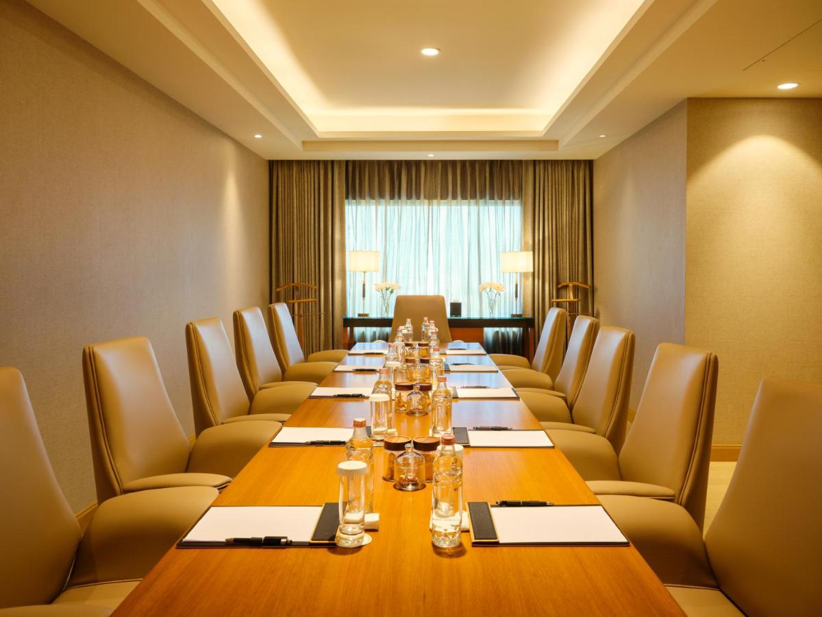 a conference room with a long table and chairs at The Leela Hyderabad Banjara Hills in Hyderabad