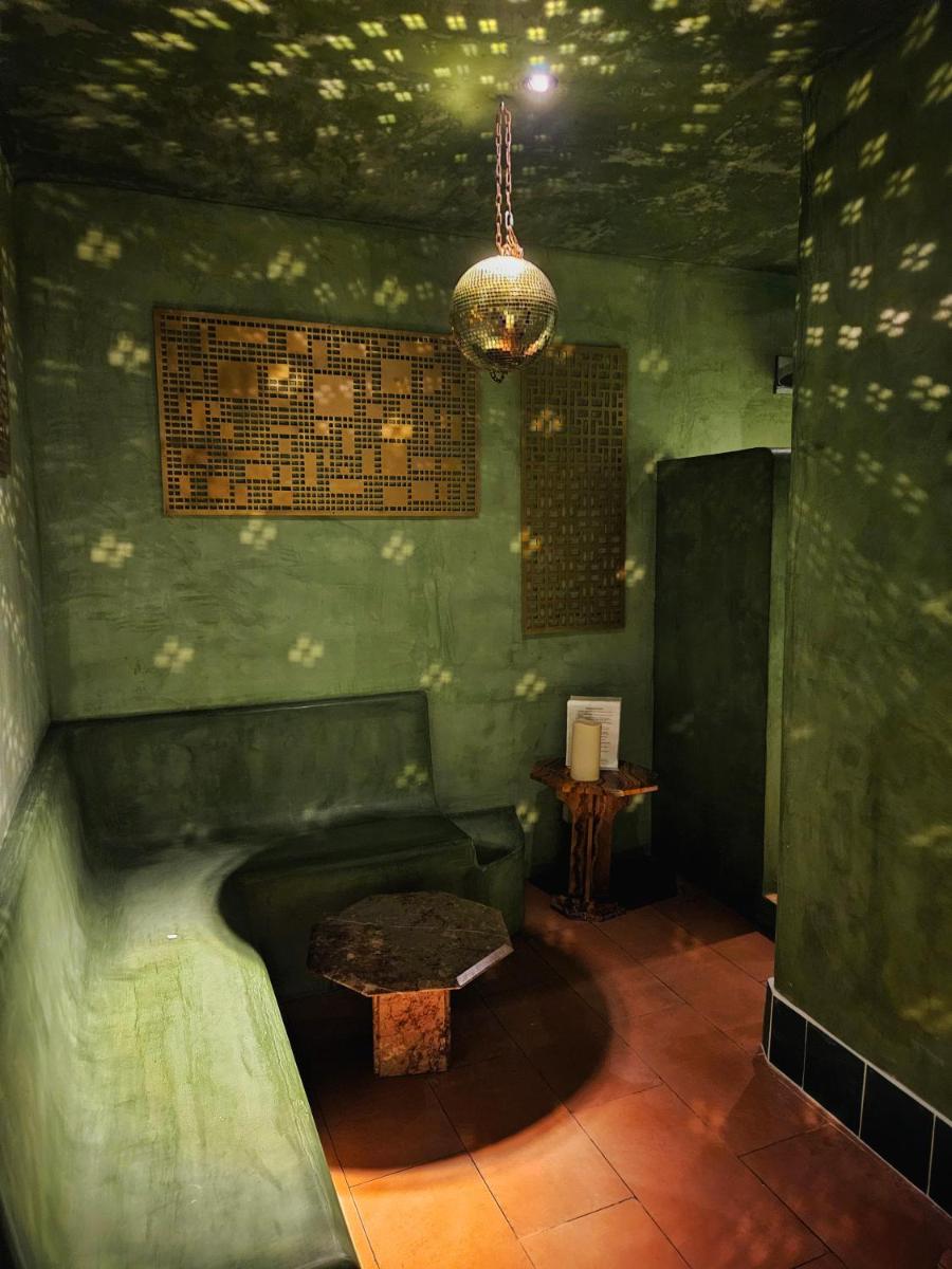 une salle verte avec un banc et une table dans l'établissement Hôtel La Nouvelle République & Hammam, à Paris 102 autres photos