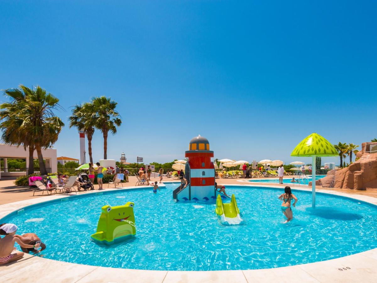 una piscina en un complejo con gente jugando en él en Hotel Fuerte El Rompido, en El Rompido