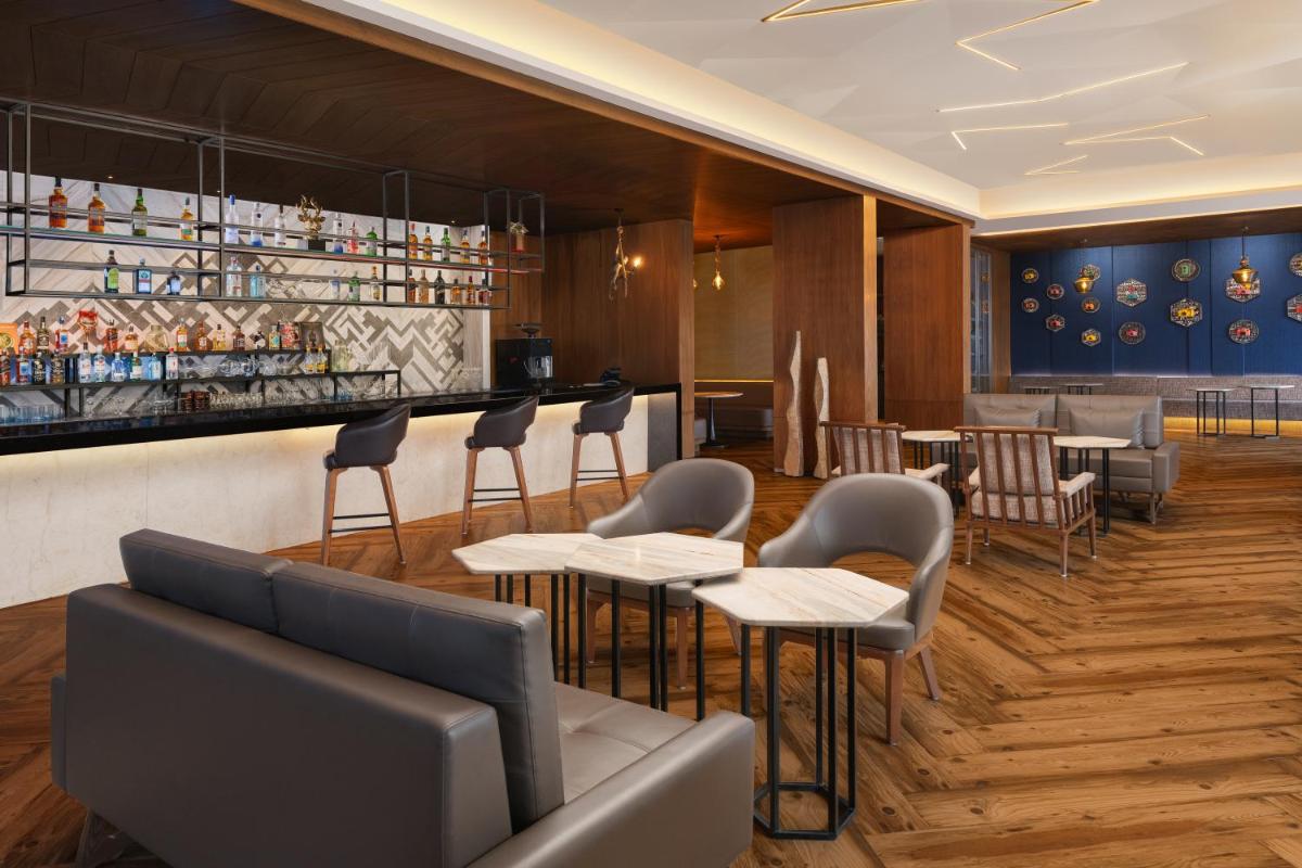 a restaurant with tables and chairs and a bar at Courtyard by Marriott Amritsar in Amritsar