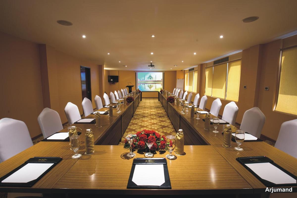 a large conference room with a long table and white chairs at Hotel Clarks Shiraz in Agra