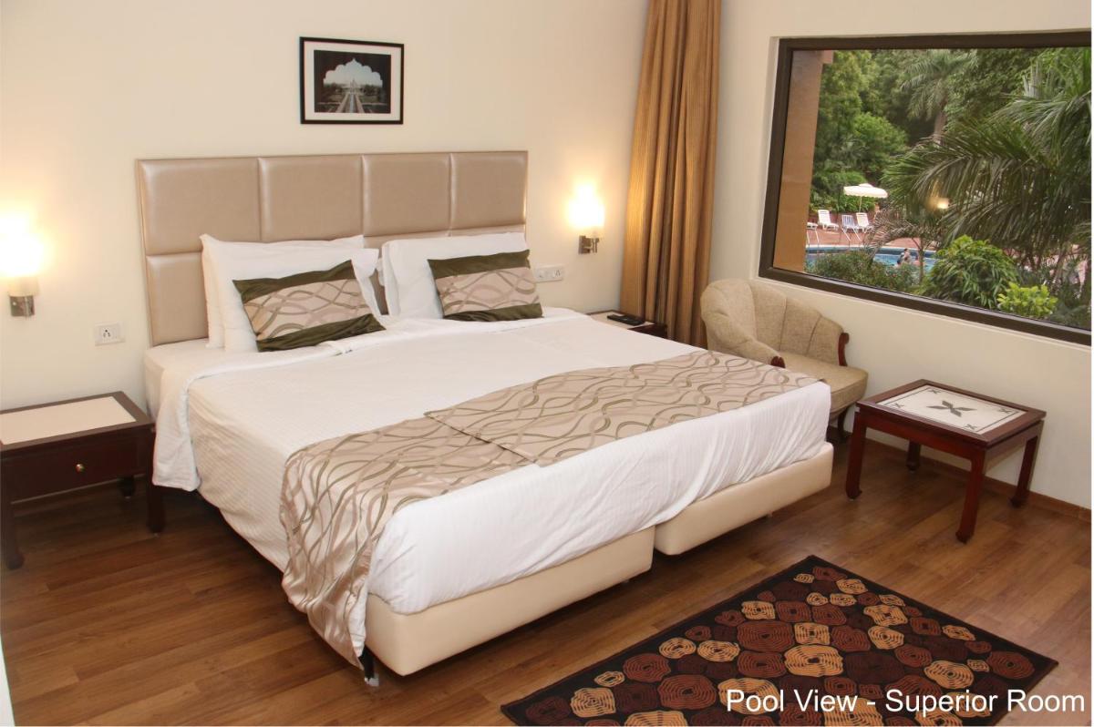 a bedroom with a large bed and a large window at Hotel Clarks Shiraz in Agra