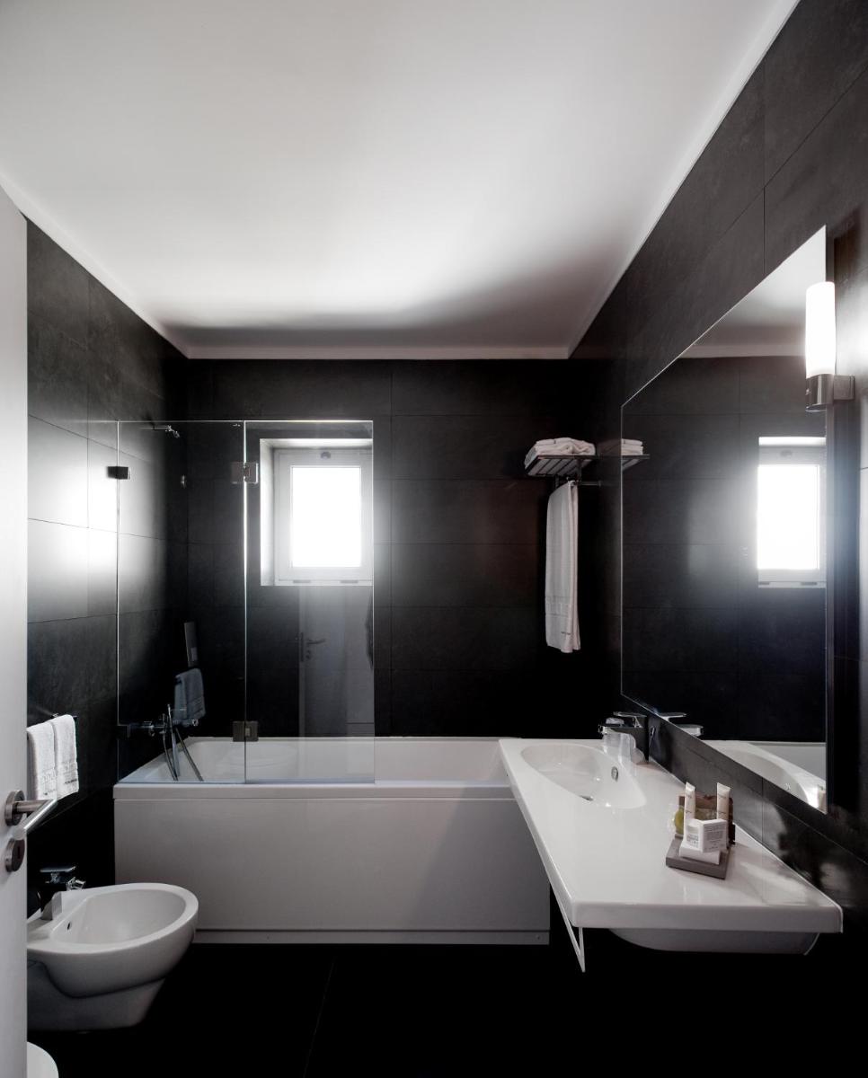 um banheiro com banheira, pia e banheira em Furadouro Boutique Hotel Beach & SPA em Ovar