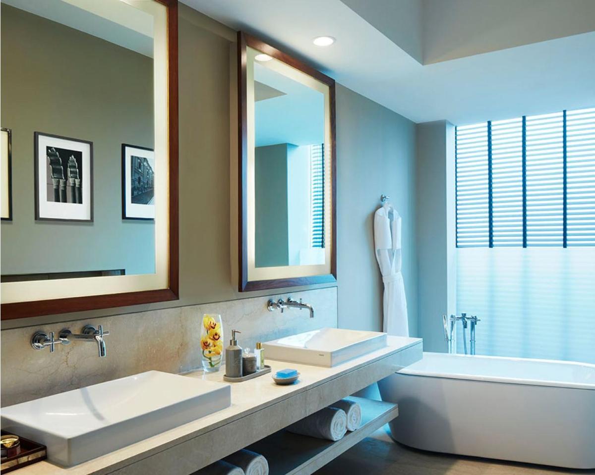 a bathroom with two sinks and a tub and a mirror at Taj Bangalore in Devanahalli-Bangalore