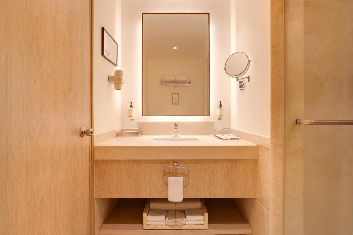 a bathroom with a sink and a mirror at Lemon Tree Premier, Ulsoor Lake, Bengaluru in Bengaluru