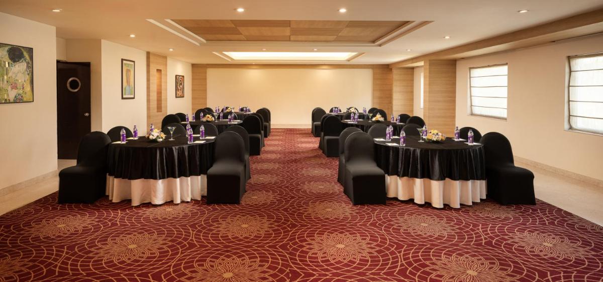 a conference room with tables and chairs in it at Lemon Tree Premier, Ulsoor Lake, Bengaluru in Bengaluru