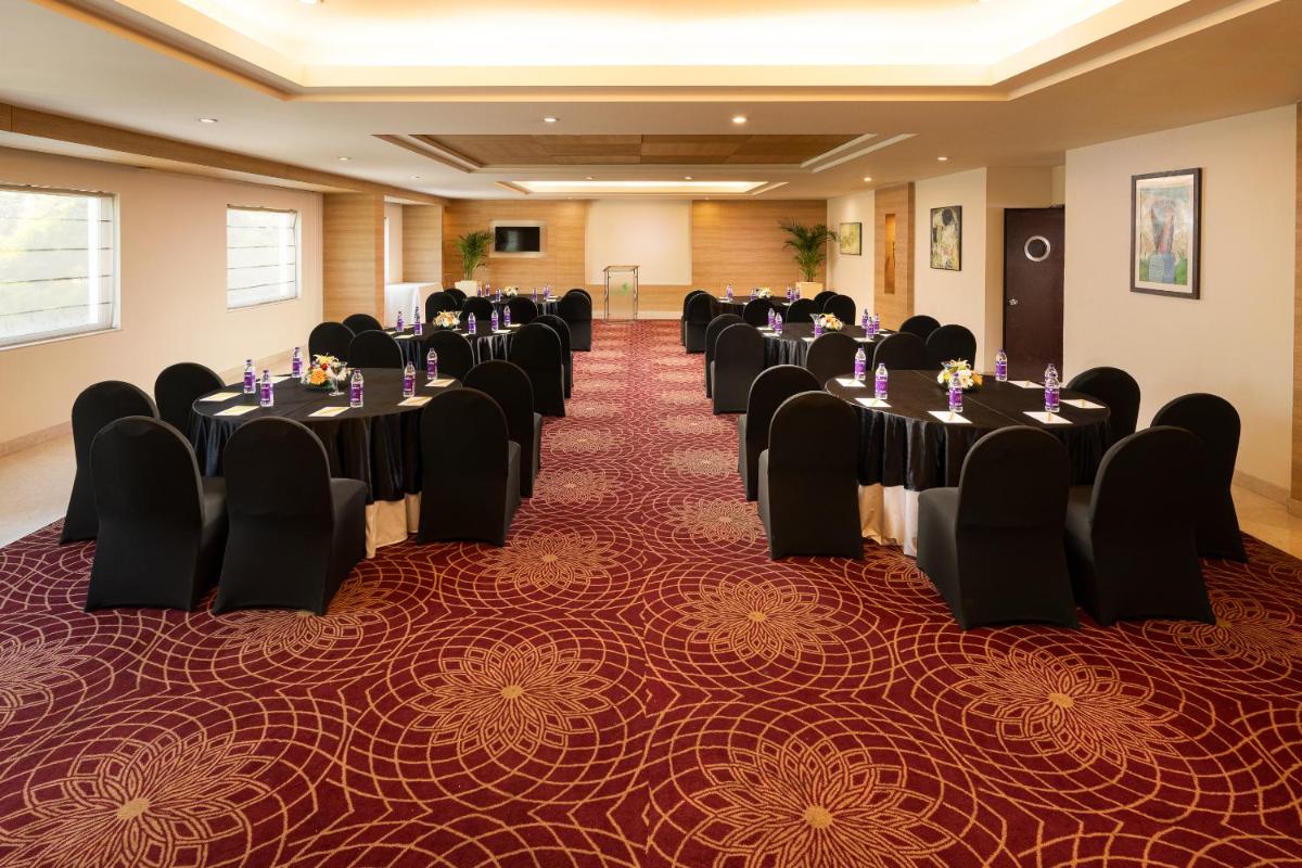 a conference room with tables and chairs in it at Lemon Tree Premier, Ulsoor Lake, Bengaluru in Bengaluru