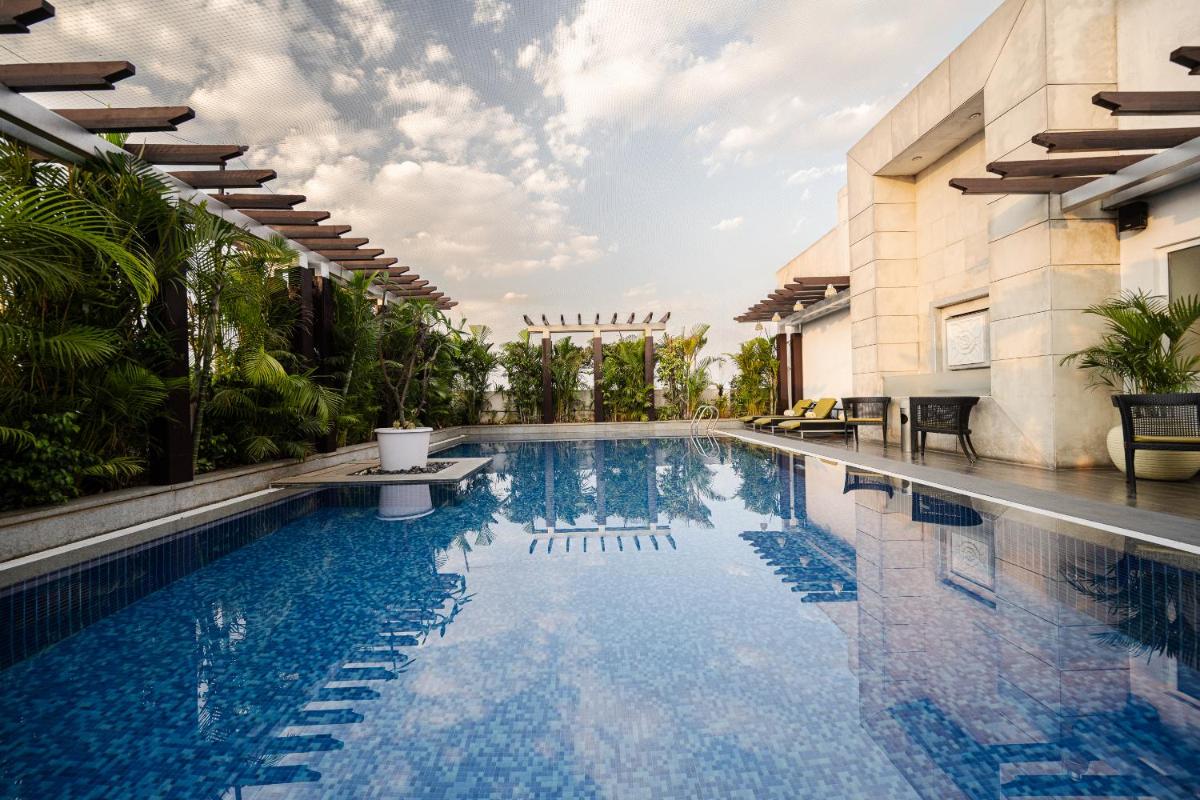 a swimming pool next to a building at Lemon Tree Premier, Ulsoor Lake, Bengaluru in Bengaluru a swimming pool next to a building at Lemon Tree Premier, Ulsoor Lake, Bengaluru in Bengaluru