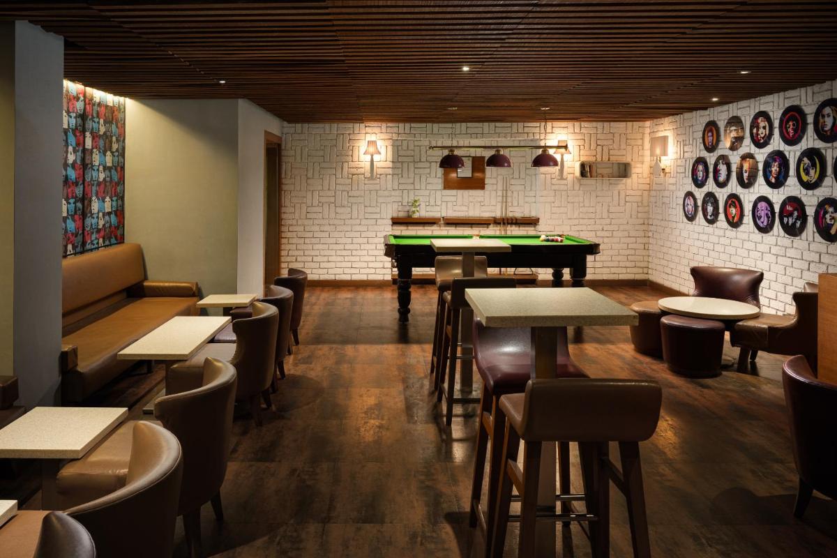 a restaurant with tables and a pool table at Lemon Tree Premier, Ulsoor Lake, Bengaluru in Bengaluru