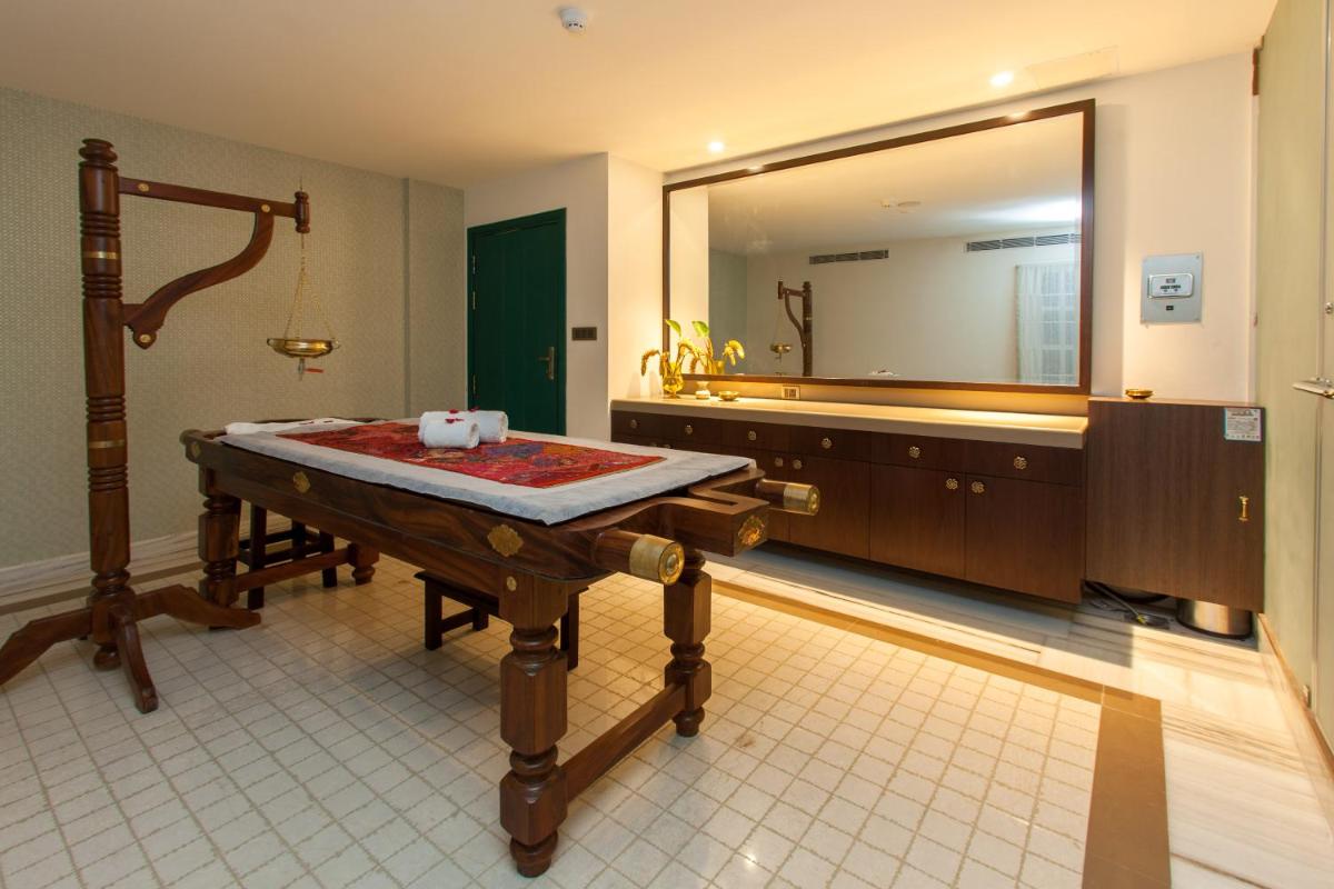 a bathroom with a sink and a large mirror at Fragrant Nature Kochi - A Five star Classified Hotel in Cochin