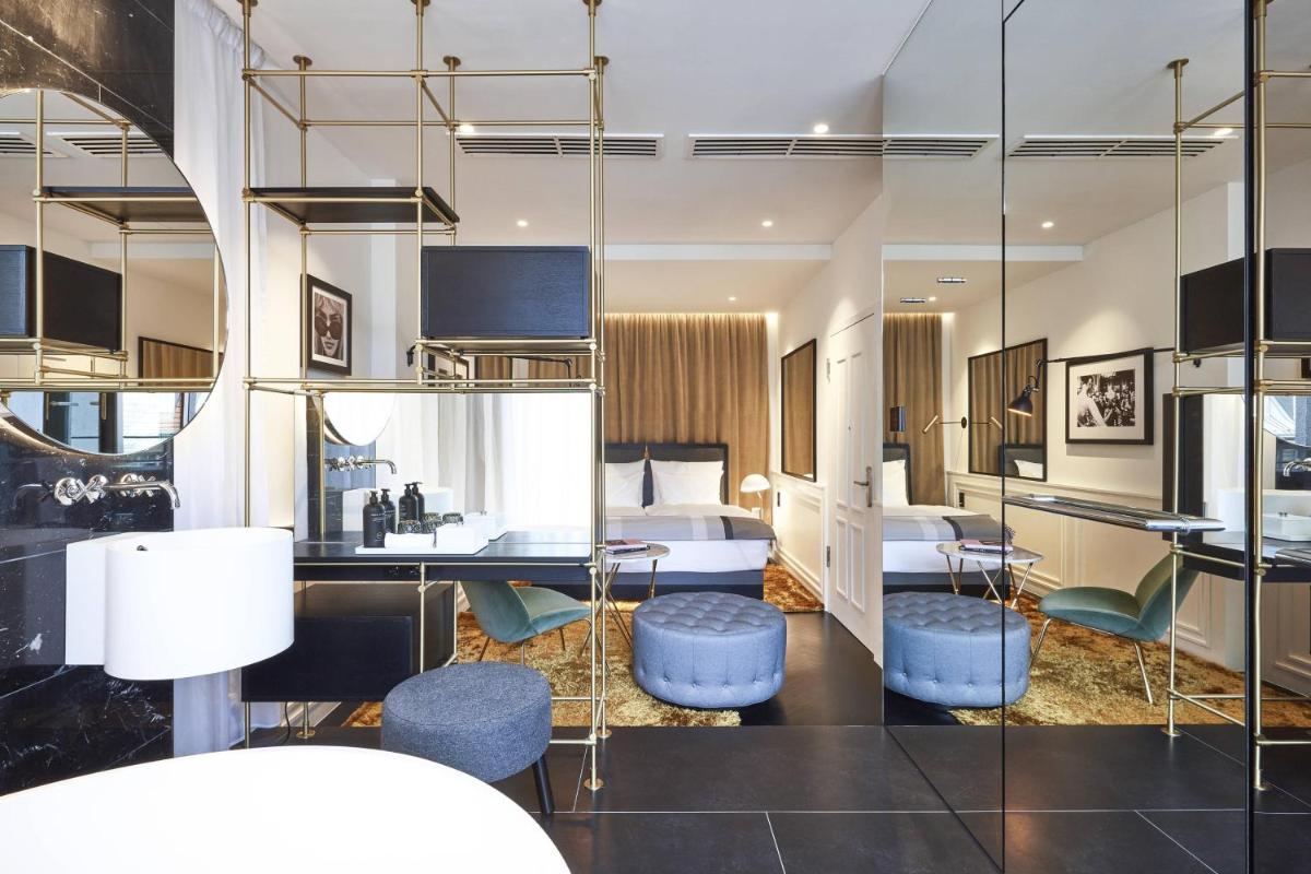 ein Hotelzimmer mit einem Bett und einem Schreibtisch in der Unterkunft Roomers Munich, Autograph Collection in München ein Hotelzimmer mit einem Bett und einem Schreibtisch in der Unterkunft Roomers Munich, Autograph Collection in München