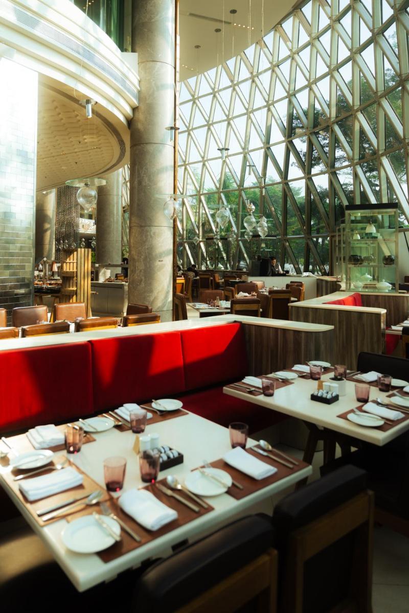 a dining room with tables and chairs and a building at JW Marriott Hotel Kolkata in Kolkata