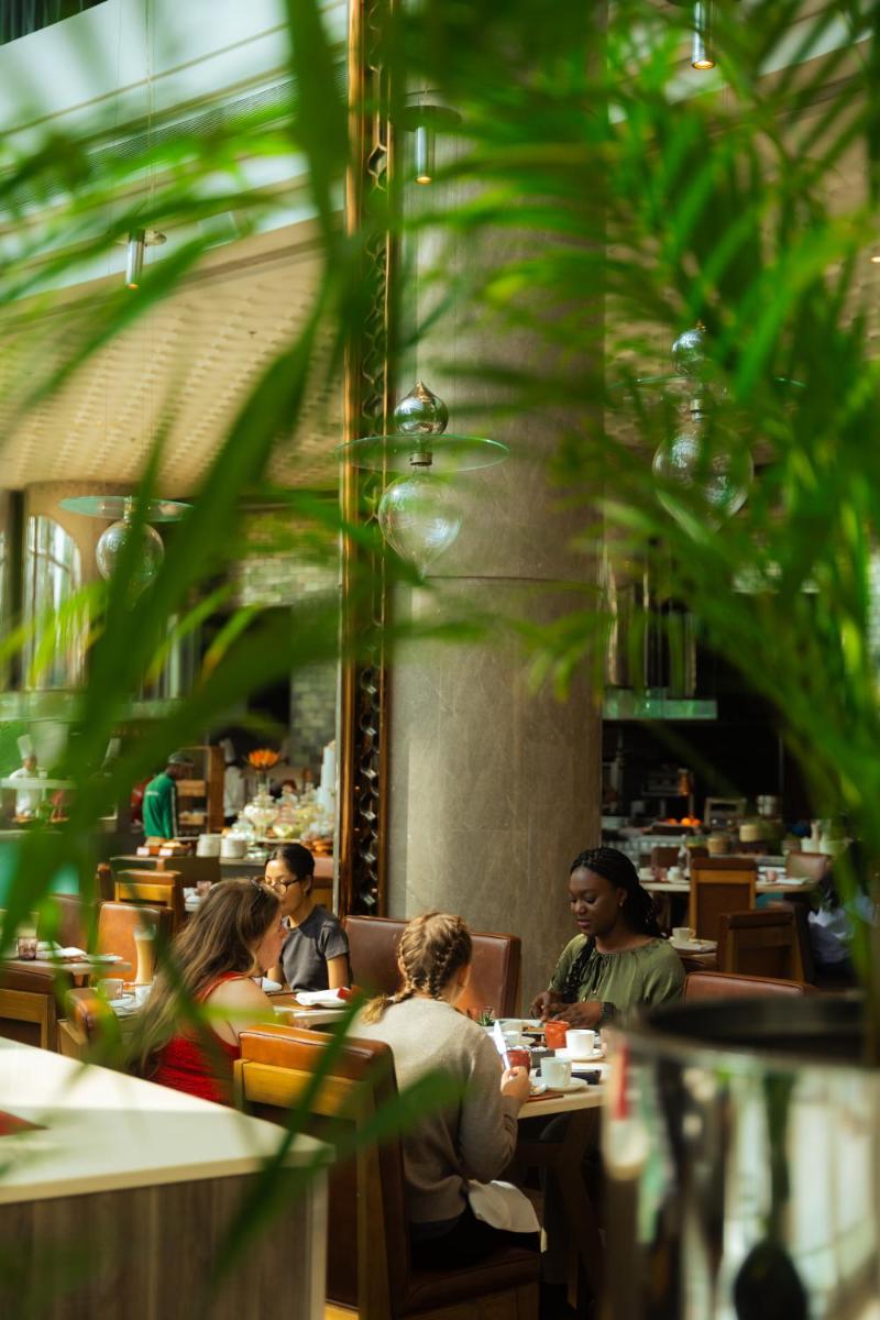 a group of people sitting at tables in a restaurant at JW Marriott Hotel Kolkata in Kolkata