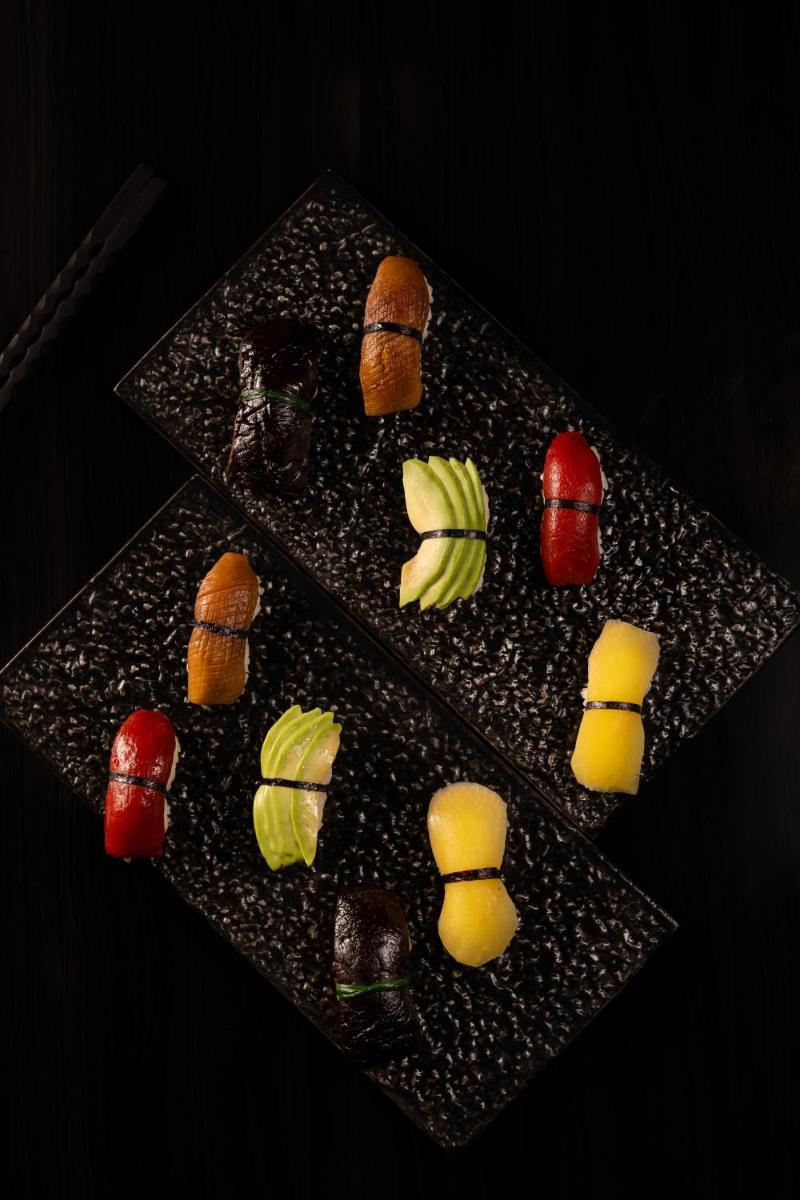 a black plate topped with different types of food at JW Marriott Hotel Kolkata in Kolkata