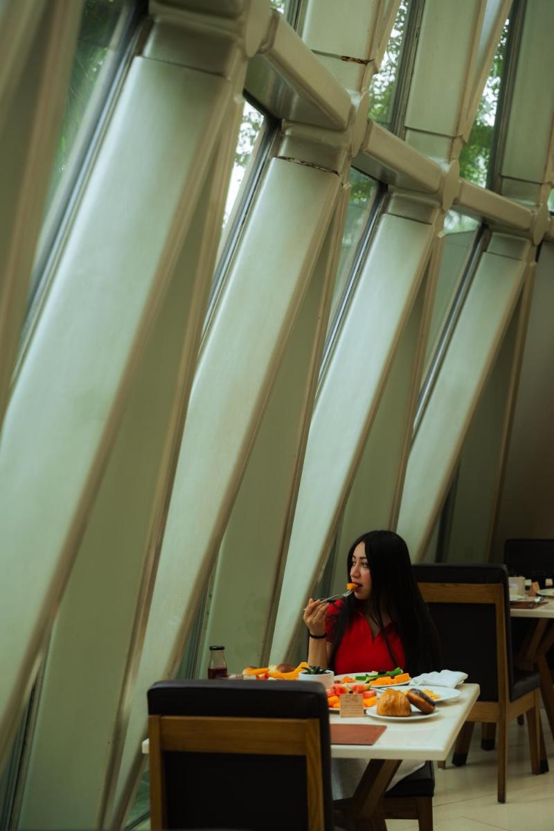 a woman sitting at a table in a room at JW Marriott Hotel Kolkata in Kolkata
