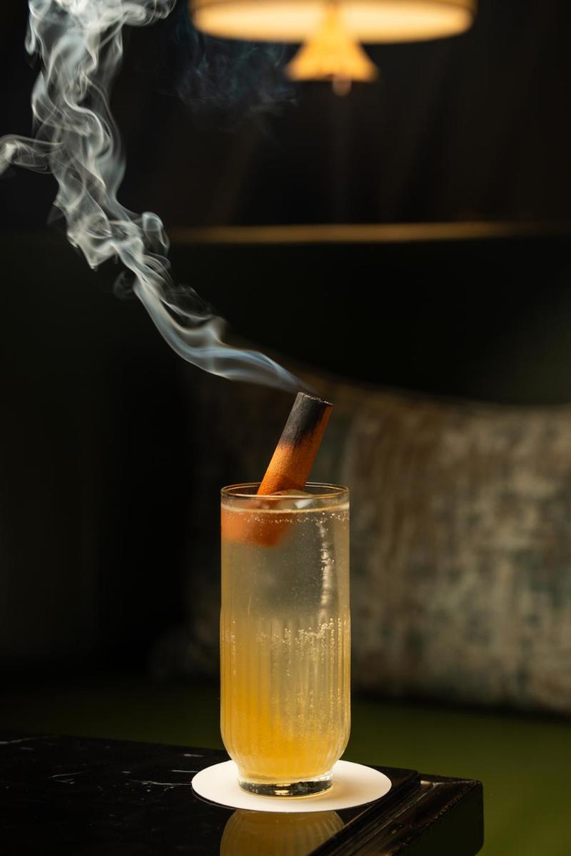 a drink with a cigarette in a glass with smoke at JW Marriott Hotel Kolkata in Kolkata