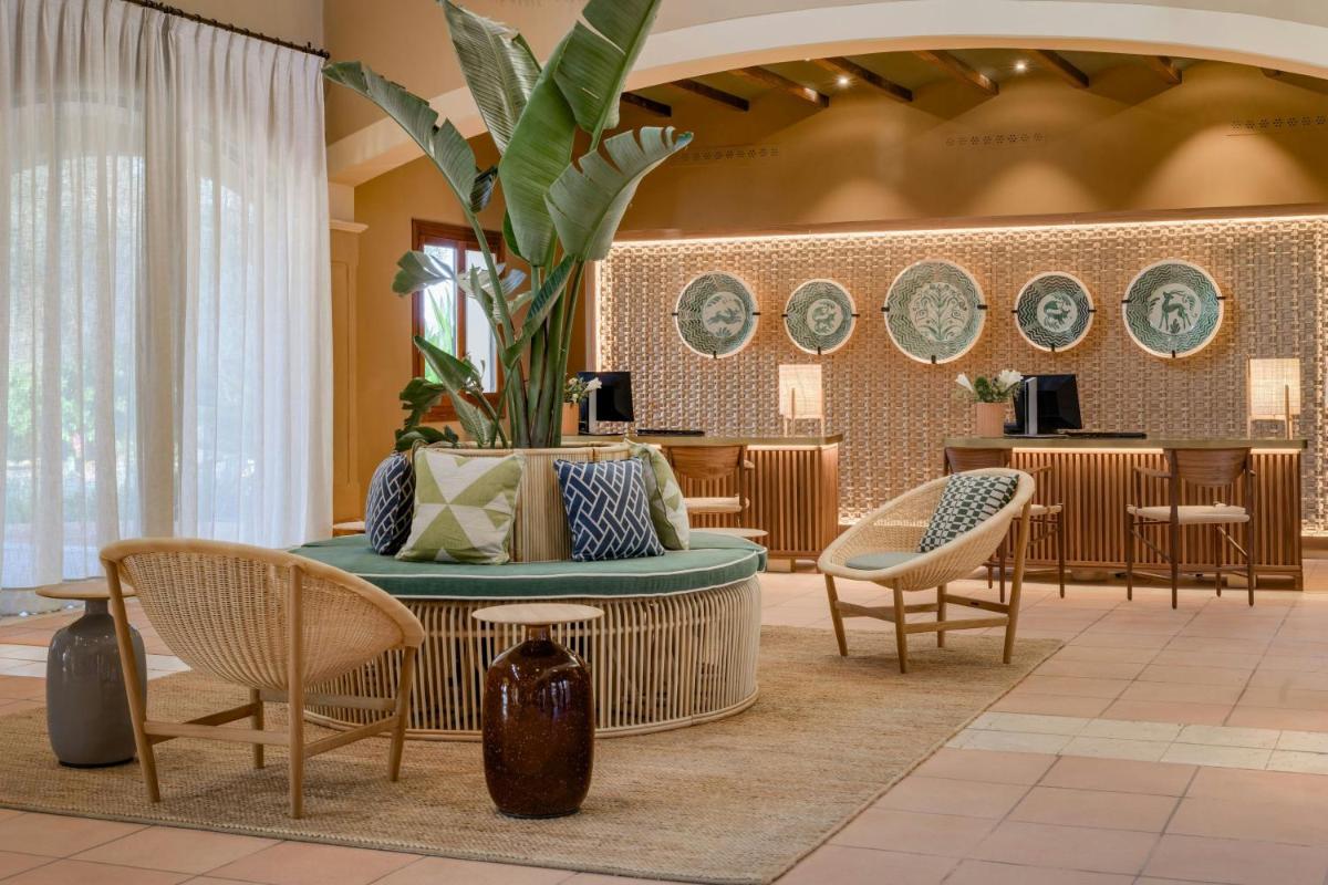 un vestíbulo con mesa, sillas y platos en la pared en Hacienda Son Antem Golf Resort, Autograph Collection, en Llucmajor