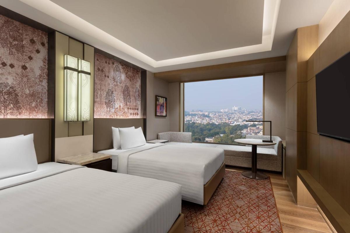 a hotel room with two beds and a window at Courtyard by Marriott Amritsar in Amritsar
