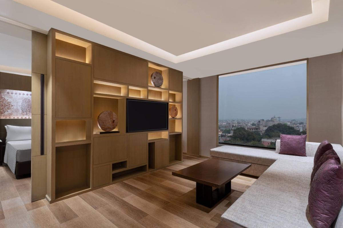a living room with a television and a large window at Courtyard by Marriott Amritsar in Amritsar