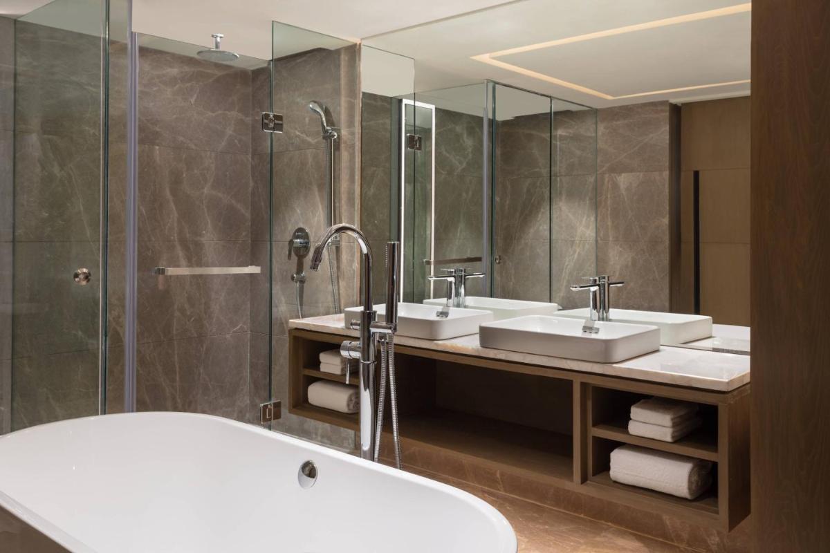 a bathroom with two sinks and a bath tub at Courtyard by Marriott Amritsar in Amritsar