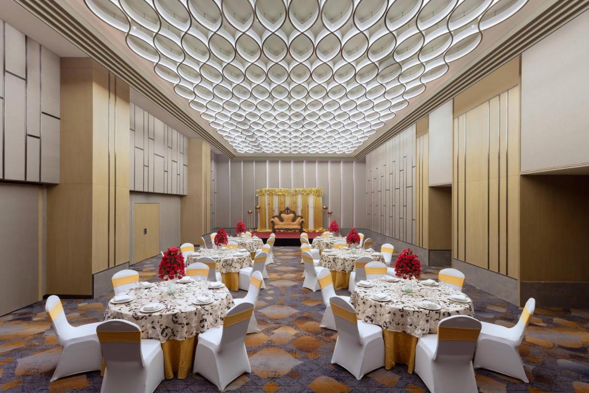 a large banquet hall with tables and white chairs at Courtyard by Marriott Amritsar in Amritsar +52 photos