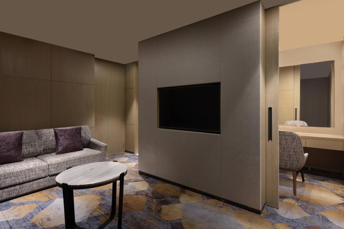 a living room with a couch and a tv at Courtyard by Marriott Amritsar in Amritsar