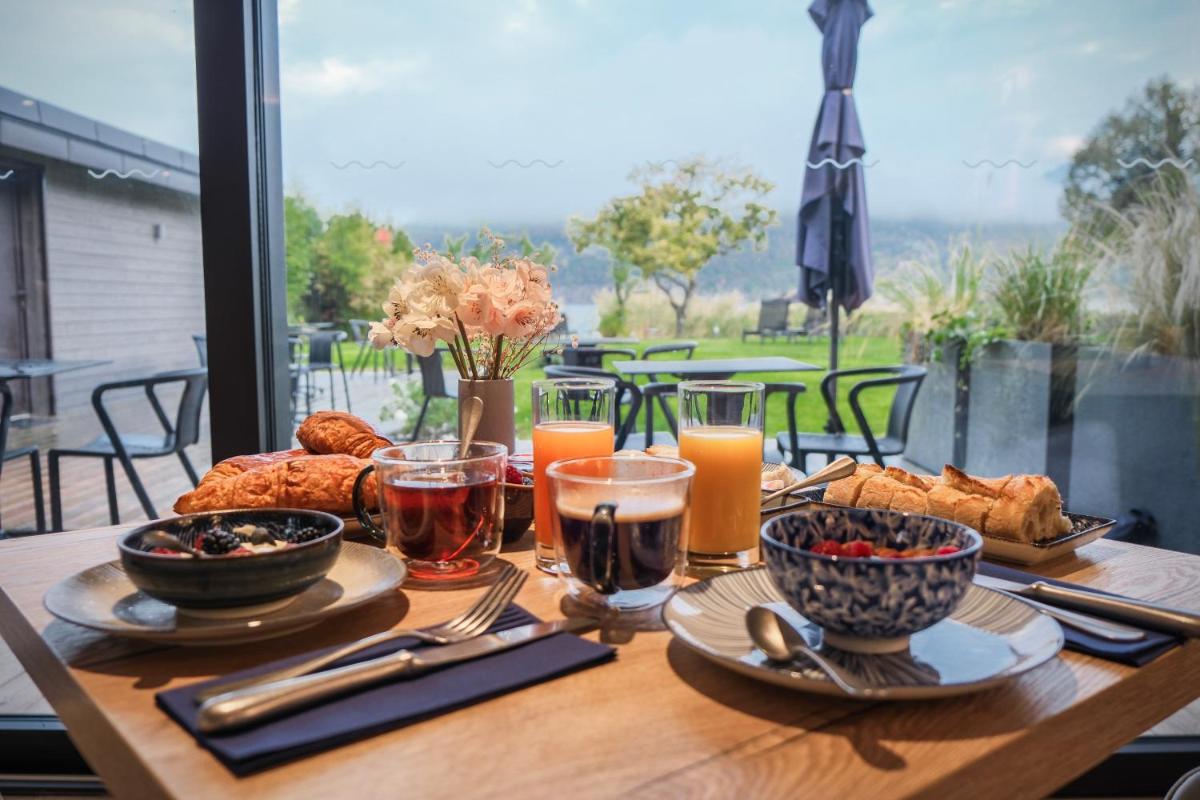 une table en bois avec de la nourriture et des boissons dessus dans l'établissement Villa Caroline, Lac d'Annecy, à Duingt