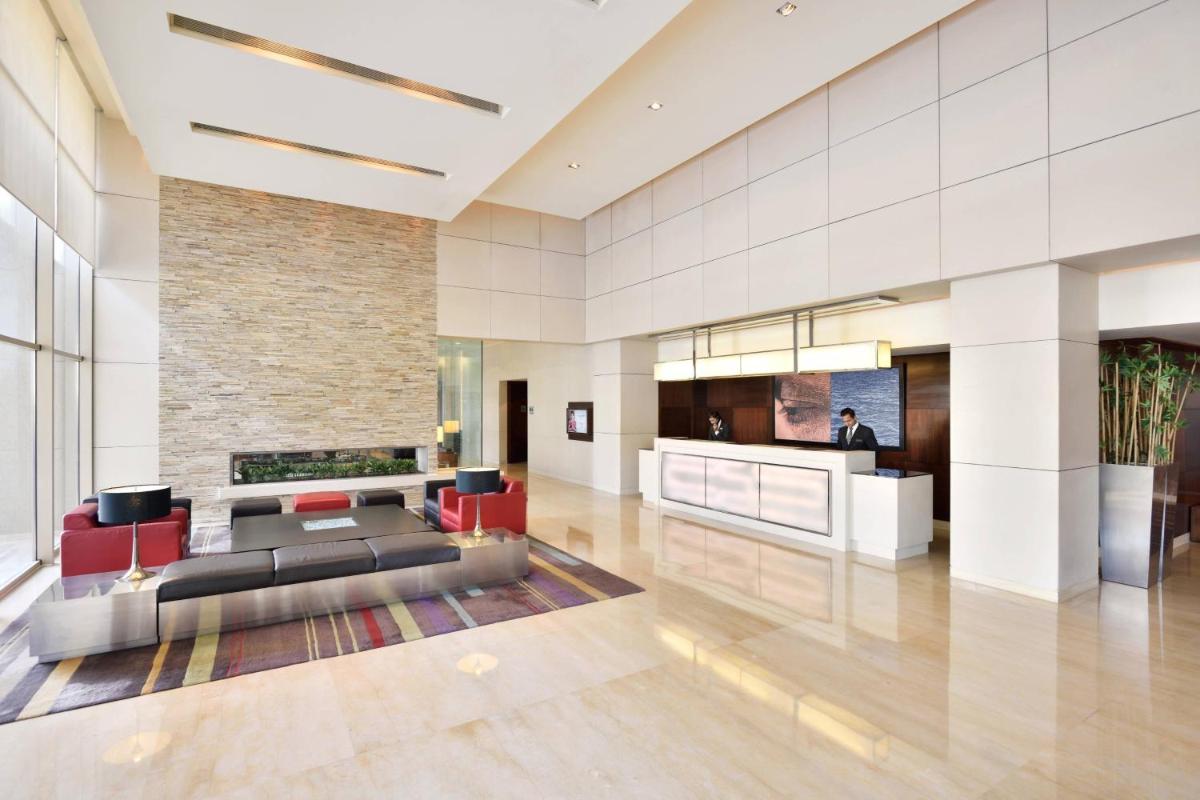 a lobby of a hotel with a couch and chairs at Courtyard by Marriott Pune Hinjewadi in Pune