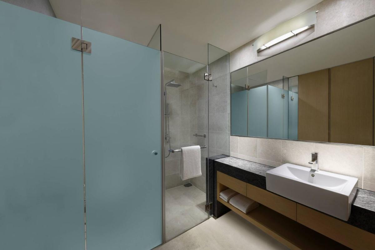 a bathroom with a sink and a mirror at Courtyard by Marriott Pune Hinjewadi in Pune