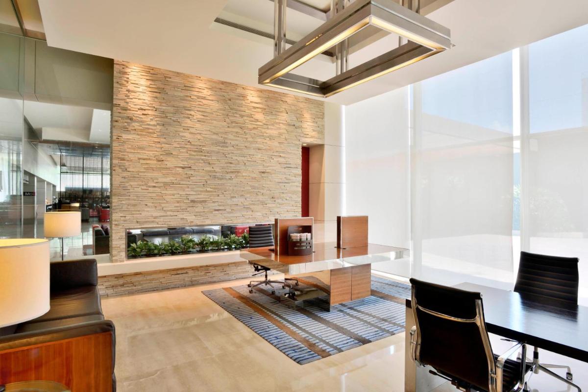 an office with a desk and a fireplace at Courtyard by Marriott Pune Hinjewadi in Pune