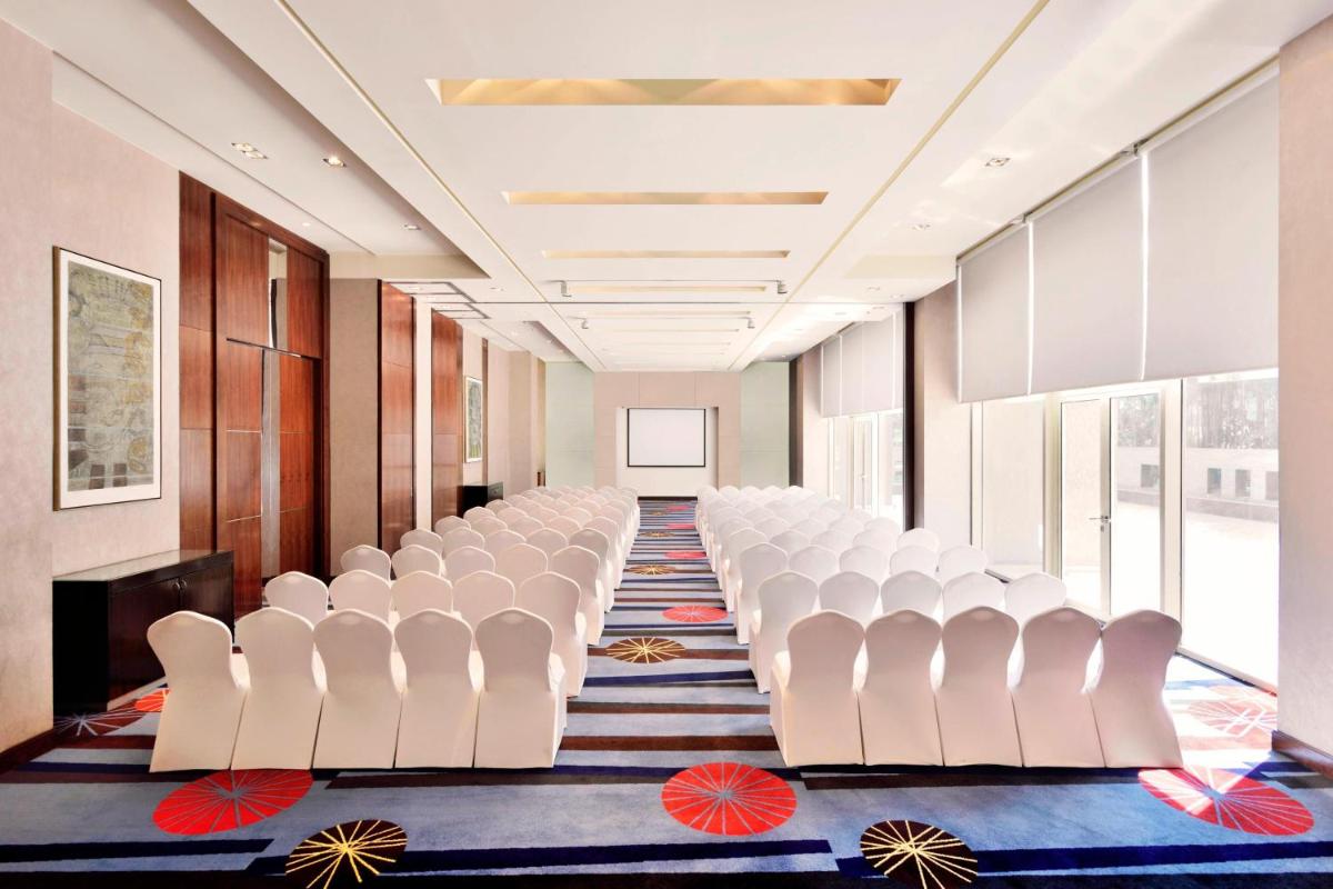 a row of white chairs in a conference room at Courtyard by Marriott Pune Hinjewadi in Pune