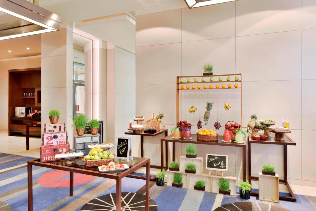 a lobby with a display of food and plants at Courtyard by Marriott Pune Hinjewadi in Pune